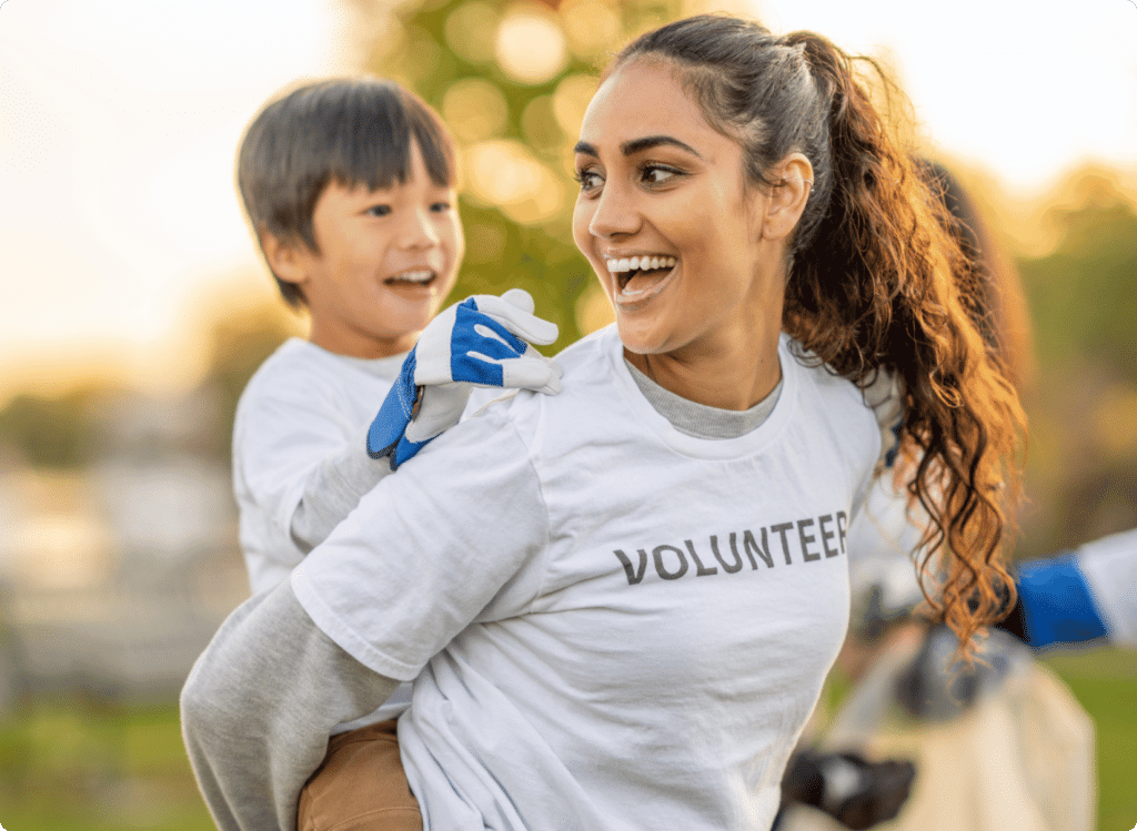 Volunteer gives a piggy back ride to excited child