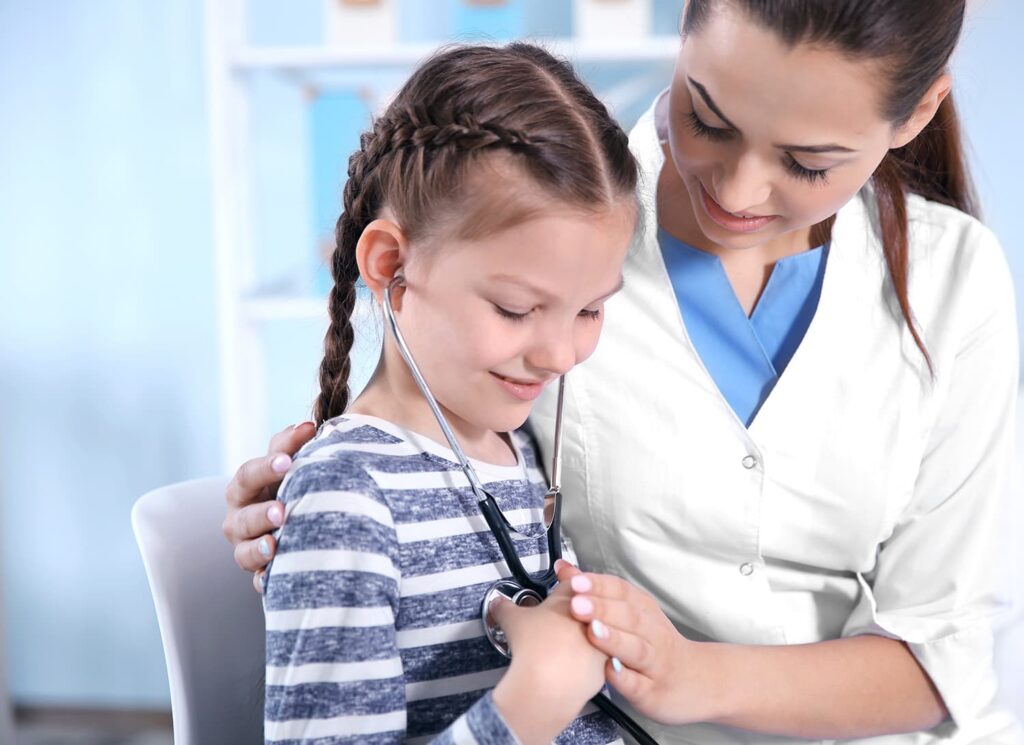 Doctor helps young child listen to their heart with a stethoscope